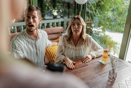 A man and a woman complaining to the wait staff at a restaurant table