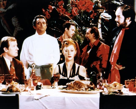 People sitting and at standing near a table with an elaborate meal on it