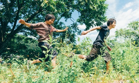 Hinata Hiiragi and Soya Kurokawa in Monster,  seen from side on running happily through vegetation on a sunny day