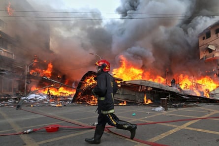 A firefighter runs towards the inferno.