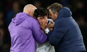 Son Heung-min is comforted by Spurs staff after his foul on André Gomes.