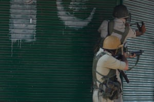 Government forces aim a sling shot and pellet-gun towards Kashmiri Muslim protesters during clashes