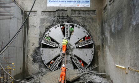 A 540-tonne boring machine breaks through the earth south of the Thames after completing a tunnel which now links the Docklands Light Railway to Woolwich as part of an ambitious expansion project.