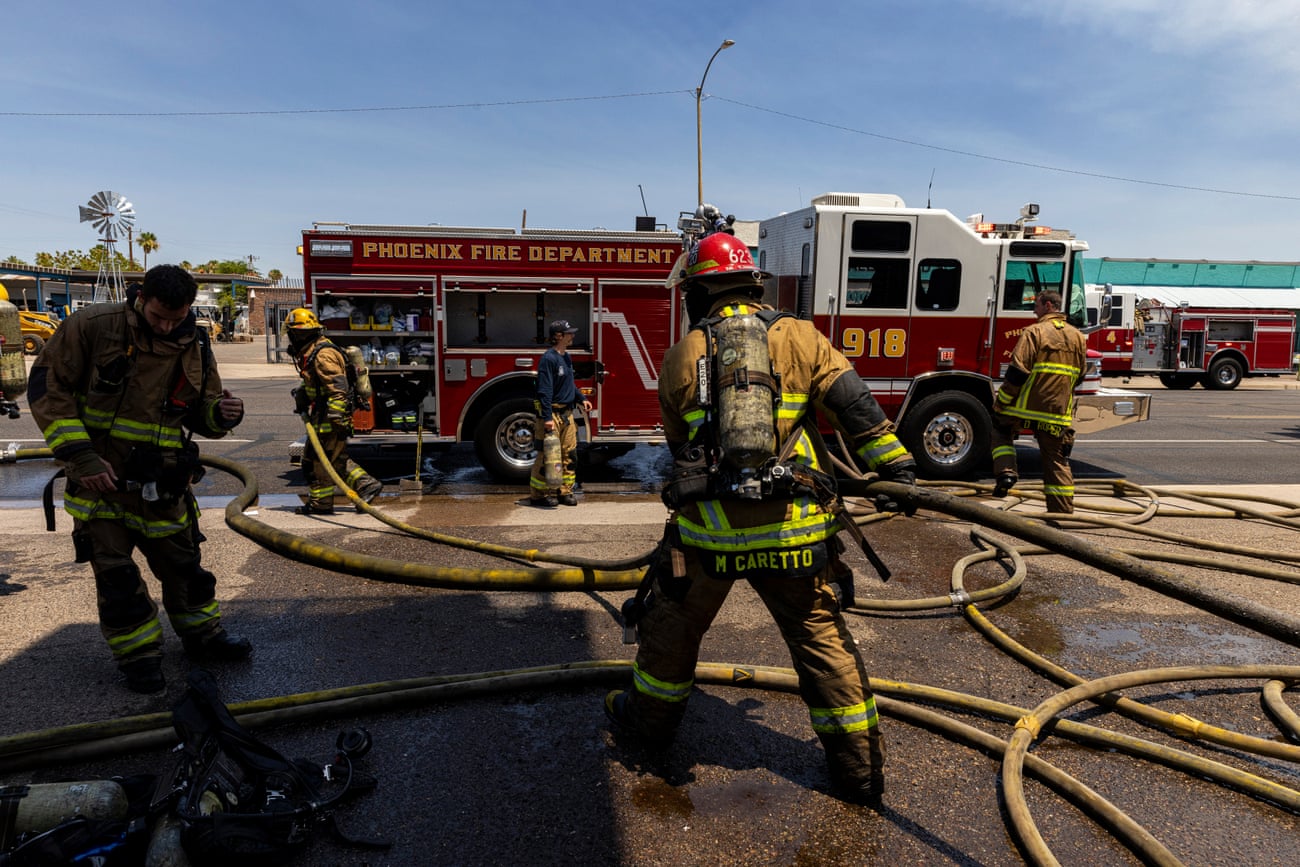 Firefighters adjusting a long yellow hose