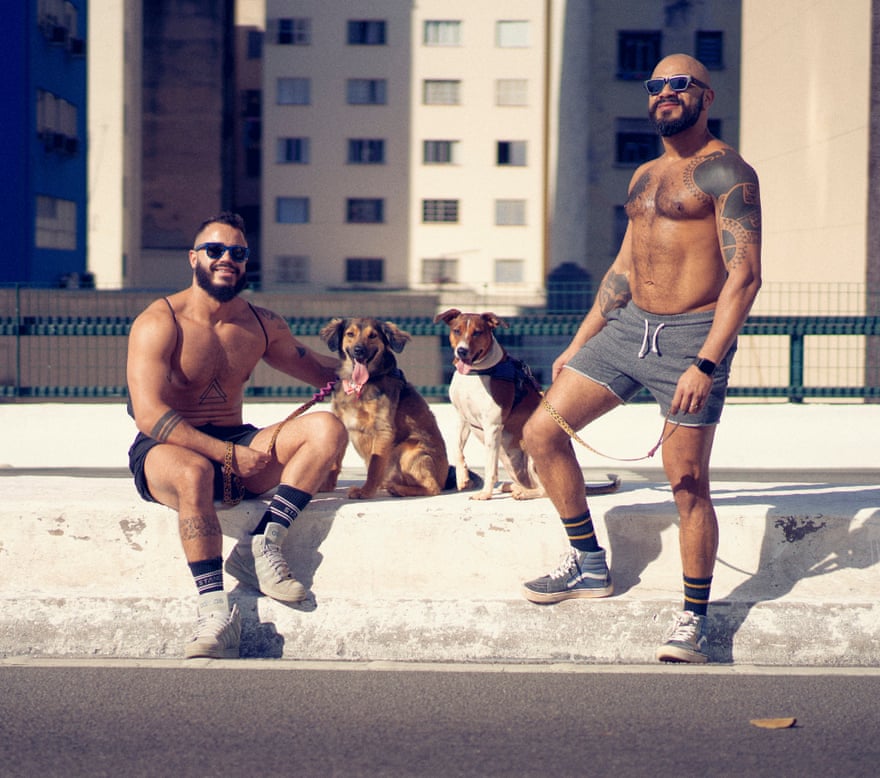 Tiago Miranda and Mário Miranda posing for a portrait with their dogs