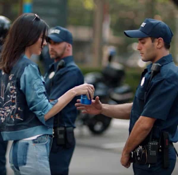 A still from the Pepsi advert featuring Kendall Jenner handing a can to a police officer.