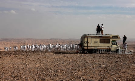 Spencer Tunick and his crew give instructions from the top of an RV.