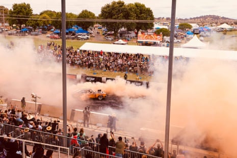 Crowds watch a car doing a burnout during the Summernats car festival at Exhibition Park in Canberra