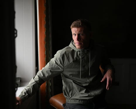 A profile picture of James McLean wearing an olive green jacket, has a serious expression