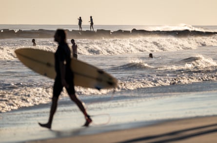 Surfers and others spend a day at Rockaway Beach as impact from Hurricane Lee delvers large surf and rip tides to much of the north-east on 14 September in New York City.