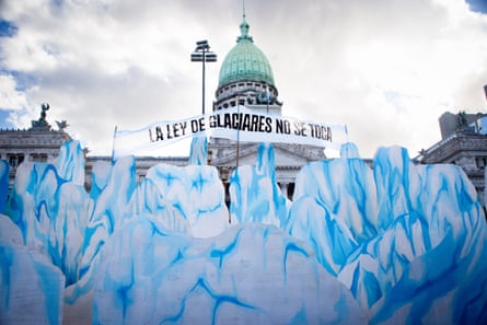 Painted panels representing glaciers stand outside the parliament building under a sign in Spanish that reads ‘The glacier law is untouchable’