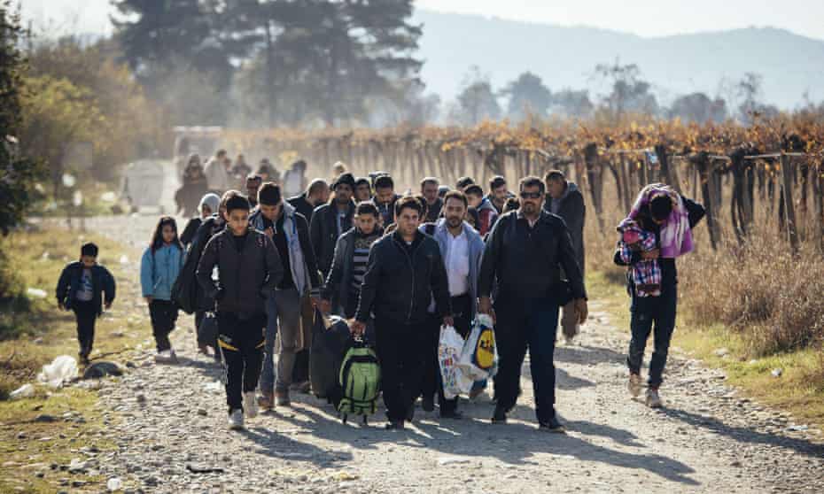 Migrants walk after crossing the Greek-Macedonian border near Gevgelija