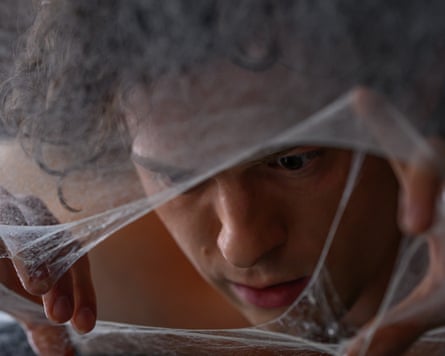Peter Parker (Tom Holland) peers through the web.