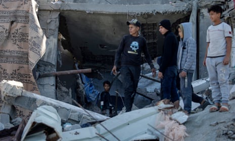Palestinians inspect a destroyed house after an Israeli airstrike in Deir al Balah, central Gaza