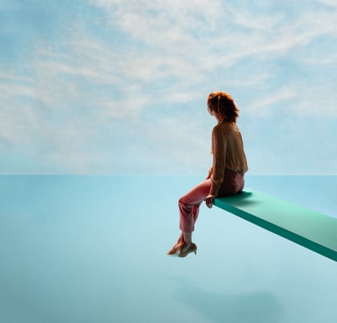 A model sitting on a diving board looking at the horizon