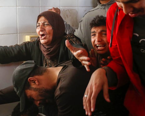 Palestinians mourn for their relatives killed in Israeli strikes in central Gaza on Monday