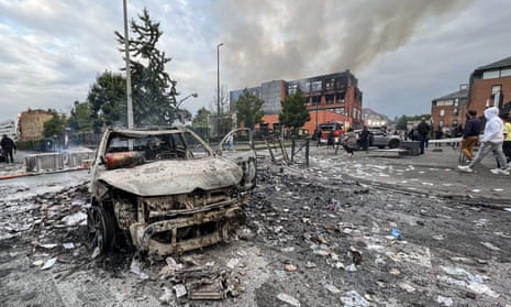 A burnt out vehicle in front of the fire damaged Tessi group building in the Alma district of Roubaix.