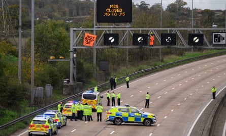 Police officers on the M25 after an activist put a Just Stop Oil banner on the gantry during the motorway protest in November 2022.