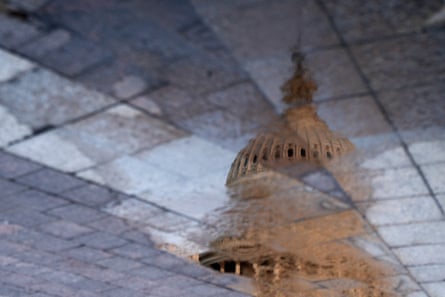 domed building seen through puddle on ground outside