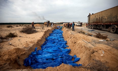 Palestinians bury unidentified people killed in the Israeli airstrikes in a mass grave in the town of Khan Younis.