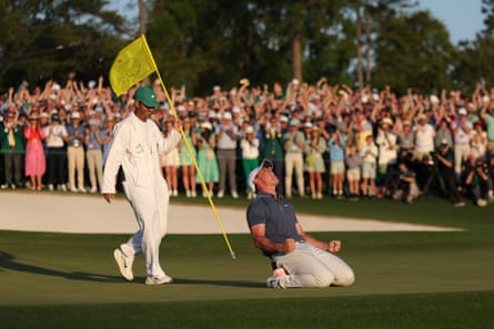 McIlroy sinks to his knees after landing the winning putt.