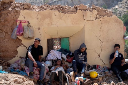 A family shelters near a damaged building in Targa, Marrakesh, after a 6.8-magnitude earthquake struck Morocco.