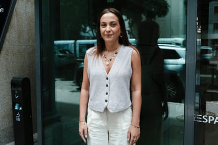 Mélanie, who lives in Lyon, outside her office in a white vest and trousers