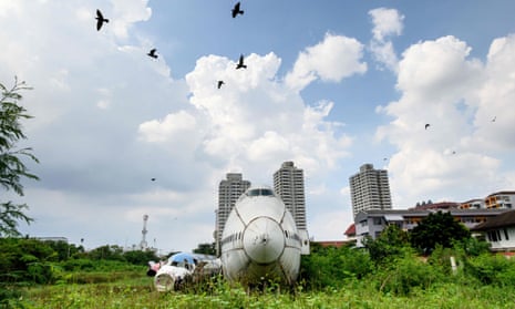 Birds fly over abandoned aircraft in the suburbs of Bangkok in October