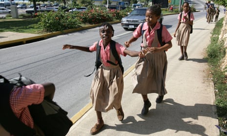 Jamaican school girls in uniform walk home from school