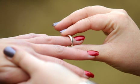 A bride places a wedding ring on her partner's finger in Canberra