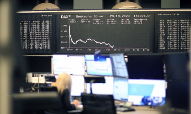 A broker sits under the display showing the downward trajectory of the German DAX index.