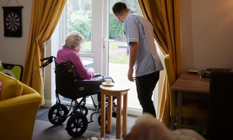 A care worker and resident look out the window of a care home in Southampton.