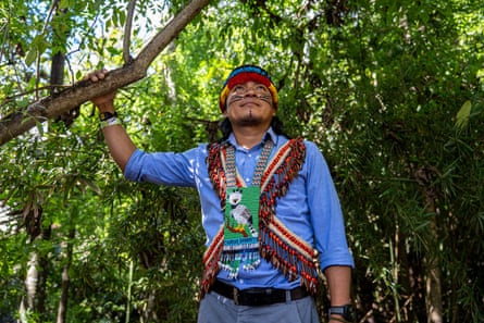 A young Indigenous man with beaded sashes and face paint