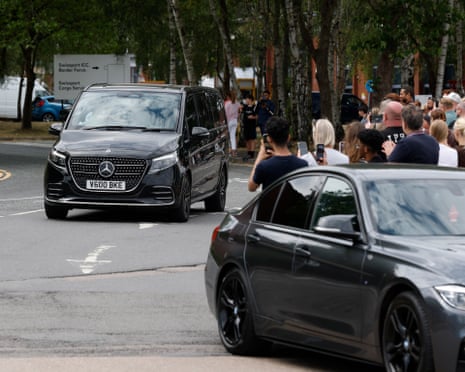 Fans watch as the players are driven out of the airpot.