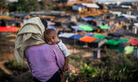 A Rohingya woman holds a baby in her arms at Kutupalong Rohingya refugee camp in Coxs Bazar.
