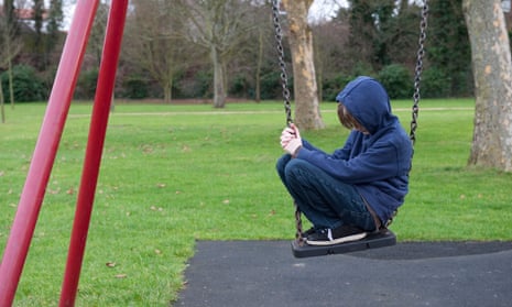 Boy sitting on swing in playground