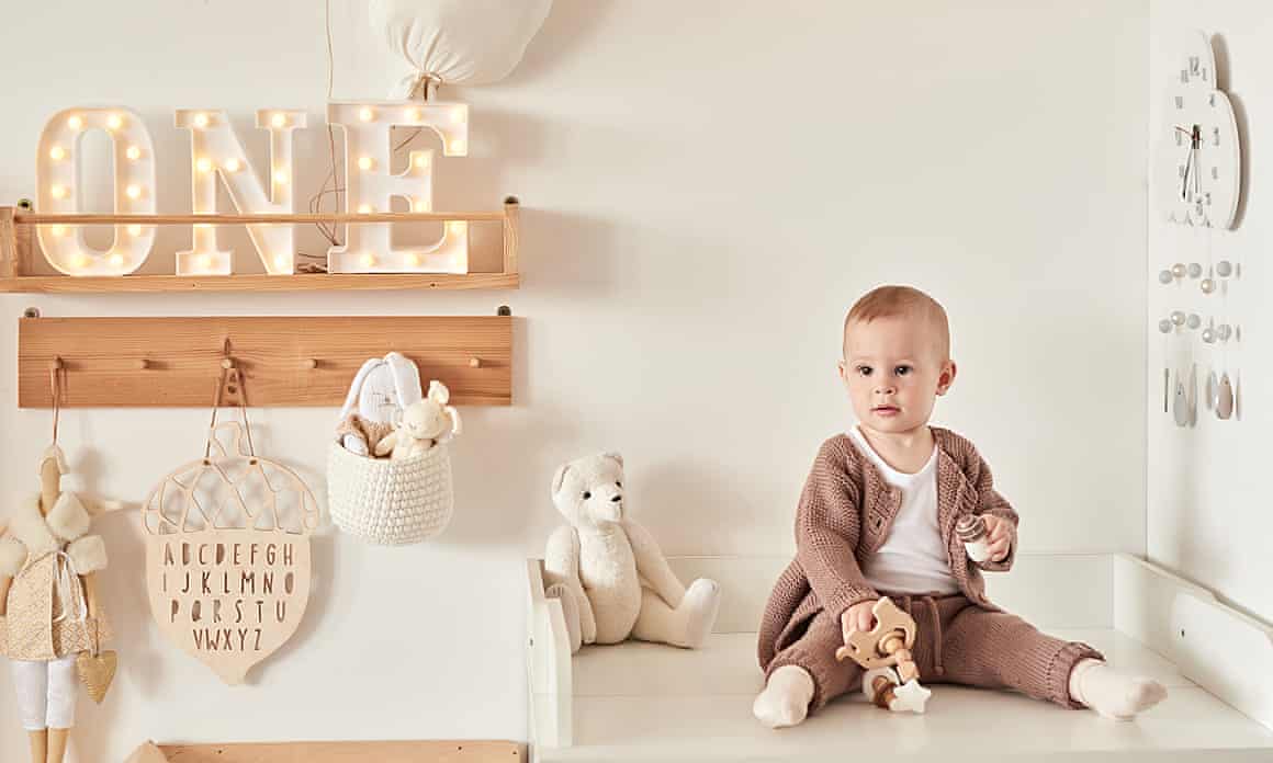 baby in beige in a beige bedroom with toys