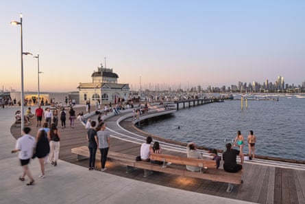 People mingle on deck in front of building at end of pier 