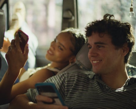 Two young people in a car smile