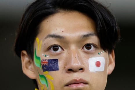A fan with Japan and Australia flags painted on their cheeks.