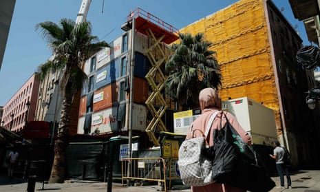 People walk by the construction site of the first building built with shipping containers in Barcelona.