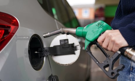 Someone puts fuel in their car at the pump