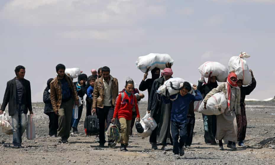 Syrians forced to flee Raqqa city carry their belongings as they leave a camp in Ain Issa