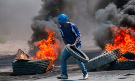 A demonstrator builds a barricade of flaming tyres during protests in Port-au-Prince on 17 September.