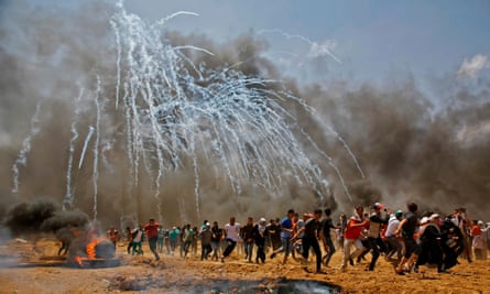Palestinian protesters run from teargas fired by Israeli security forces on the border of Gaza, May 2018
