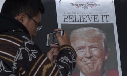 Zheng Gao, from Shanghai, China, takes a picture of the front page of a newspaper featuring Donald Trump.