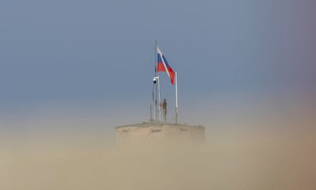 A Russian soldier stands on top of a water tower at Khmeimim airbase.