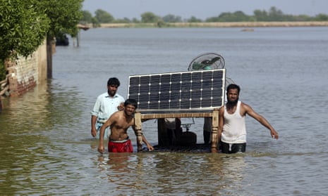 People use a cot to salvage belongings from their flooded home, in Jaffarabad, Pakistan.