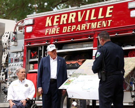 Donald Trump and Texas governor Greg Abbott receive a briefing from first responders as they visit a scene of devastation in Kerr county, Texas.