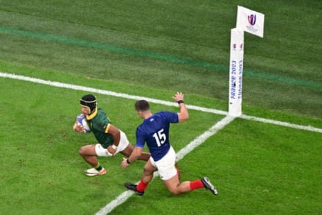 South Africa's wing Kurt-Lee Arendse (L) runs past France's full-back Thomas Ramos to score a try.